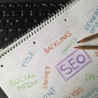 Närbild av anteckningsbok med SEO-termer och nyckelord för digital marknadsföring.