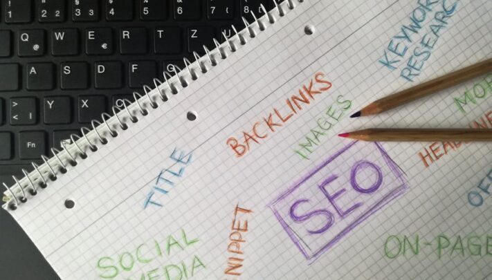 Närbild av anteckningsbok med SEO-termer och nyckelord för digital marknadsföring.