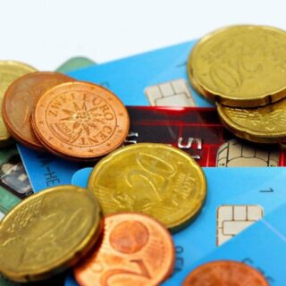 Närbild av euro-mynt och kreditkort som symboliserar val av bank för företag.